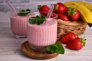 Strawberry banana smoothie on a white wooden background.