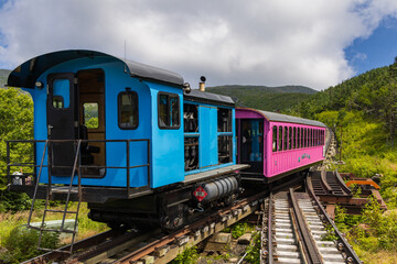 A cogwheel train passing a level junction on the Mt Washington railway track in New Hamsphire,  USA