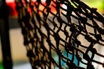 Close-up shot of a hand-woven made net tied with many knots of dense threads in decorative store