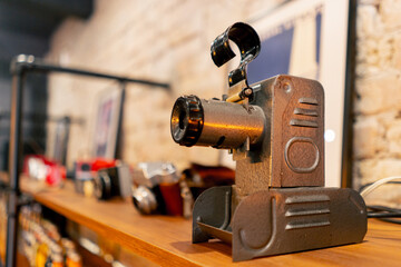 Fototapeta na wymiar A rare antique projection device for broadcasting films stands on wooden shelf in an antiques store
