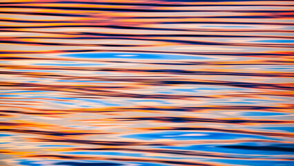 Abstract motion blur background of ripples with colorful sunset sky reflection on sea surface in evening time