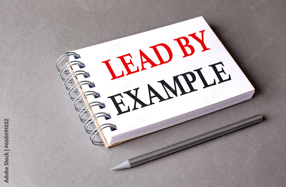 Poster lead by example word on notebook on grey background
