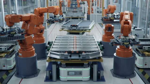 Time-lapse of EV Battery Pack for Automotive Industry Assembled on Production Line with Orange Robotic Arms.  Automated Electric Car Smart Factory. Battery Manufacturing Line Equipped with Robot Arms