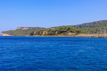 Fototapeta premium View of the rocky shore from the sea. Mediterranean Sea in Turkey. Popular tourist places. Background