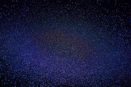 Black dark indigo blue gold orange glitter shiny abstract background for design. Twinkling glow stars effect. Fantastic, fantasy. Like outer space, night sky, universe. Grain, rough surface.