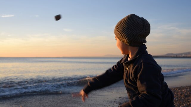 Bambino che lancia sassi (e le sue speranze) verso il cielo, verso l'orizzonte: verso il futuro!