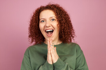 Happy cheerful excited successful woman with redhead and curls clapping hands with surprised facial...