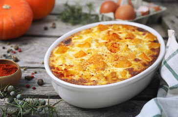 French cuisine. Vegetable pumpkin clafoutis in ceramic bakeware, smoked paprika dressing - 668700885