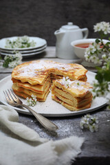 French cuisine. Matefaim. Stack of sweet Apple Pancakes, cup of tea and white spring flowers