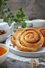 French roll raisin buns, teapot and cup of tea for sweet breakfast - 668701407