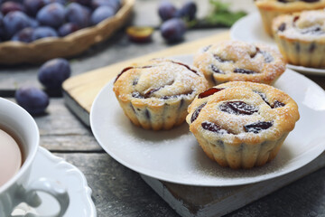Plum muffins and cup of tea, powdered sugar dressing - 668701604