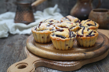 Plum muffins, cezve and cup of coffee, powdered sugar dressing - 668701673
