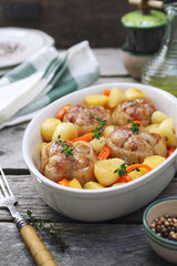 Braised meat paupiettes with potatoes and bell pepper in ceramic bakeware