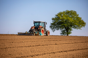 Obraz premium Tracteur labourant la terre des champs au printemps.