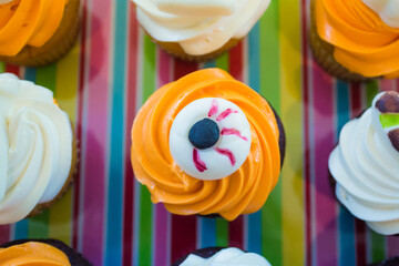 Halloween Cupcakes. Decorated cupcakes in a Halloween theme.  Orange frosting with an eyeball decoration on top.