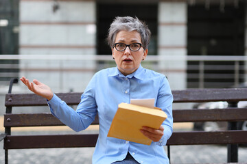 An accomplished female entrepreneur in the urban landscape, engrossed in her work and visibly...