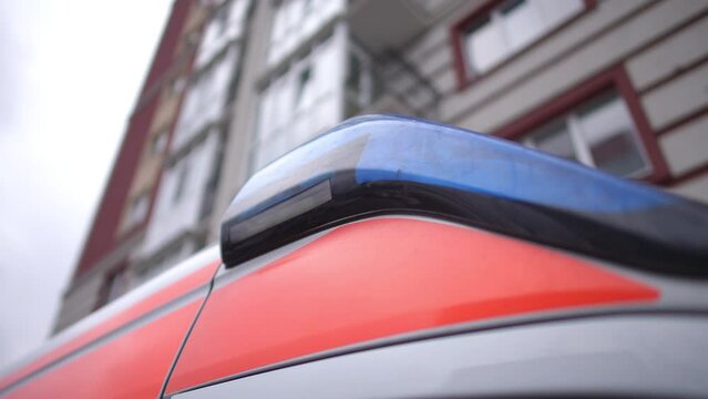 Closet parts of the door and flashing lights of an ambulance on the background of a high-rise building