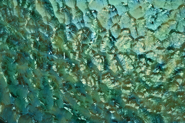 Blau-grüne Farbe schimmert durch Glasscheibe