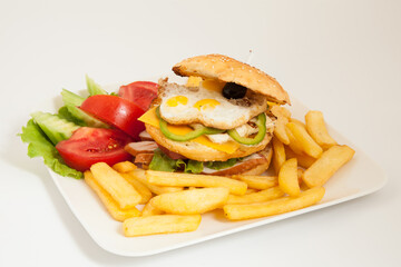 club sandwich on a white plate with french fries and vegetables