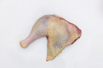 The raw leg quarter of a turkey are isolated on a white background.