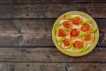 The top view of the apple pie rose shape on a rustic wooden background.