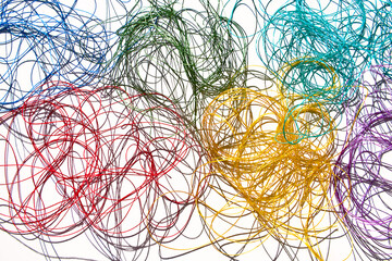 Tangled multi-colored threads on a white background