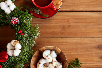 winter holidays, diy and hobby concept - close up of christmas fir wreath making stuff, decorations and hot chocolate on wooden table