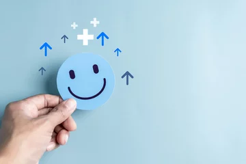 Deurstickers Hands holding blue happy smile face. mental health positive thinking and growth mindset, mental health care recovery to happiness emotion... © Kiattisak