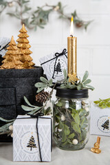 Weihnachtsgeschenke mit Kerze, Bäumen, Zweigen in den Farben schwarz gold natur - 668727446
