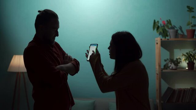 Conflict, quarrel and jealousy concept. Young couple, woman jealous, takes the smartphone from her husband, demands an explanation