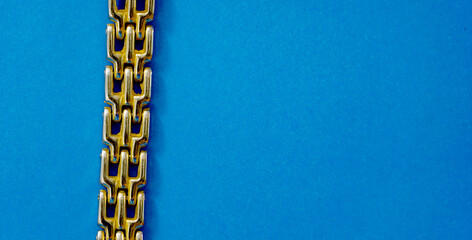 detail of a gold colored bracelet on a blue background - 668749465