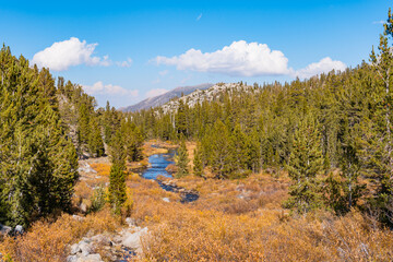 Hiking in Little Lakes Valley in the Eastern Sierra Nevada Mountains outside of Bishop, California. Alpine lakes, fall leaf colors, snow capped mountains and evergreen trees combine to make a pictures