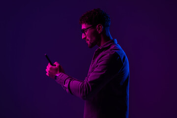 Male with smartphone on Red and blue neon light