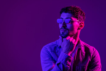 Neon light portrait of serious man beard in sunglasses