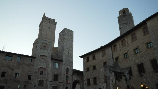 View of towers and restaurants in Piazza della Cisterna in historical centre of San Gimignano, UNESCO World Heritage Site, San Gimignano, Tuscany, Italy