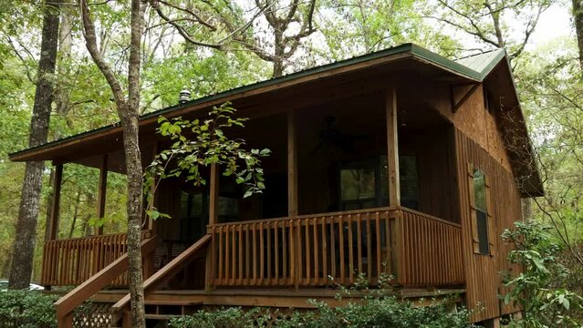 footage of a beautiful autumn landscape at Creekwood Gardens with a rental cabin, lush green trees, grass and plants,  black Tesla Model S in the driveway in Simsboro Louisiana USA