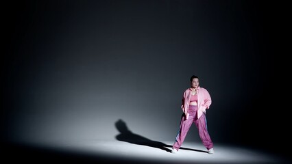 Obraz premium Attractive woman dancing jazz-funk in a studio. Black to white soft gradient background, white spotlight and distinct falling shadow. Modern choreography. Full length.