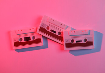 Audio cassettes in neon light. Retro wave, 80s