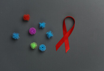 Red AIDS awareness ribbon with virus strain on dark background