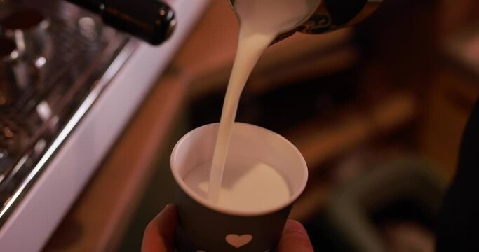 Pouring a milk into cup for preparing latte