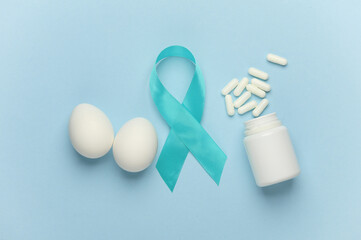 Blue ribbon symbolizing support of men, pills and eggs. Blue november prostate cancer awareness month. International Mens Health Day. Flat lay