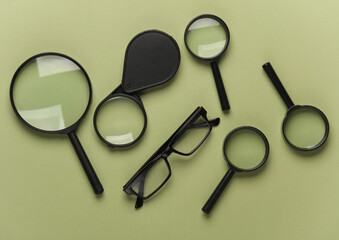 Magnifiers with eyeglasses on a green background
