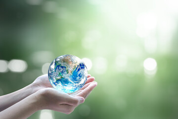 World environment day concept:Human hands holding earth globe on blurred beautiful green...