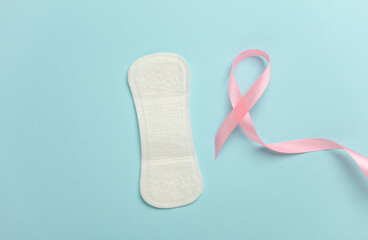 Pink ribbon, breast cancer awareness symbol with pad on blue background. Women Health