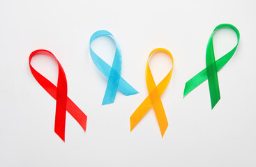 Red, blue, yellow, green awareness ribbons on white background