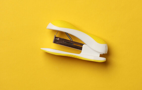 Stapler on yellow background. Top view