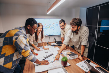 A diverse team of architects, engineers, and professionals collaborate in a board room, discussing...