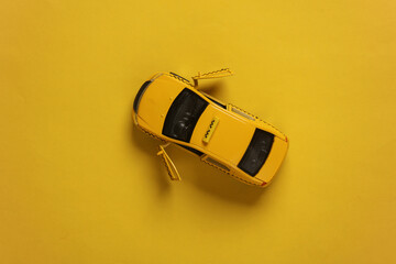 Toy model taxi car top view on yellow background