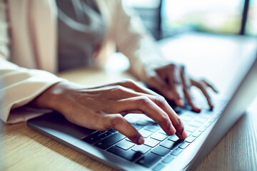 Close up of female hands typing on a laptop keyboard
