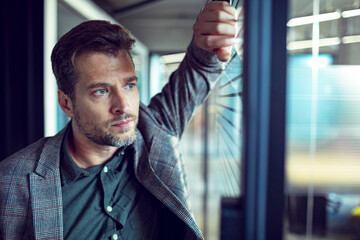 Thoughtful Man Looking Out of the Window in an Office